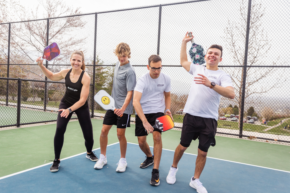 A group of pickleball players swinging pickleball paddles. Master the Sweet Spot: Ultimate Pickleball Paddle Guide.