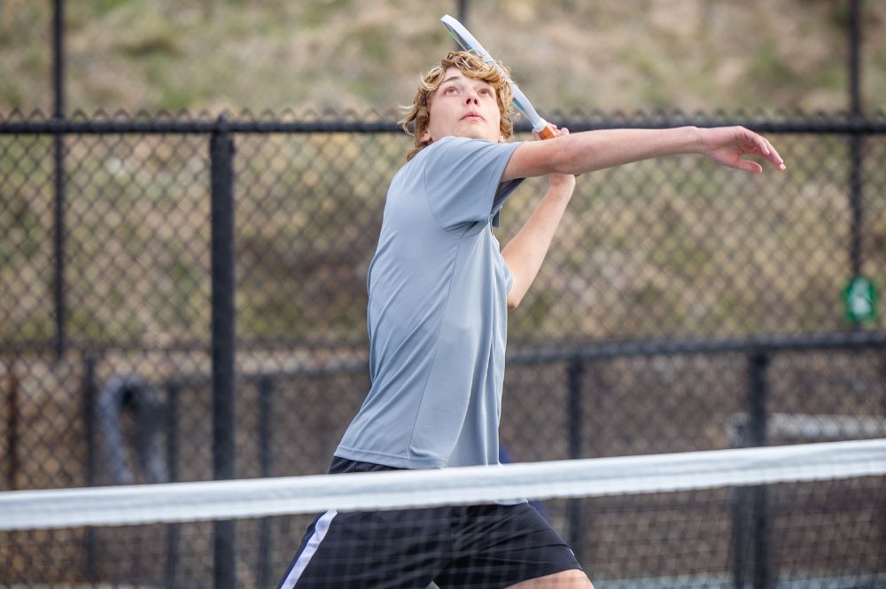 A young man prepares to hit a pickleball, showcasing kids sports confidence in action.