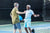 Two men playing pickleball on a court, engaging with each other.