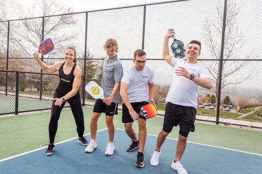A group of pickleball players swinging pickleball paddles. Master the Sweet Spot: Ultimate Pickleball Paddle Guide.