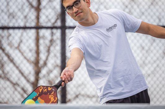 Young man hitting a pickleball. High-performance pickleball paddles designed for optimal power and control.