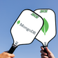 Two custom pickleball paddles with MongoDB and SCS branding against a clear blue sky.