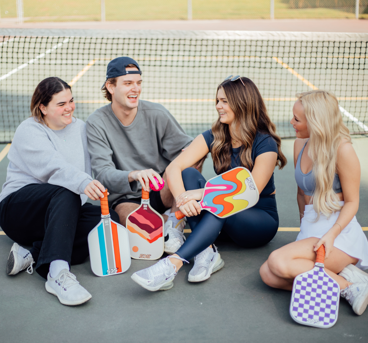 SCS Pickleball team members laughing on a pickleball court.